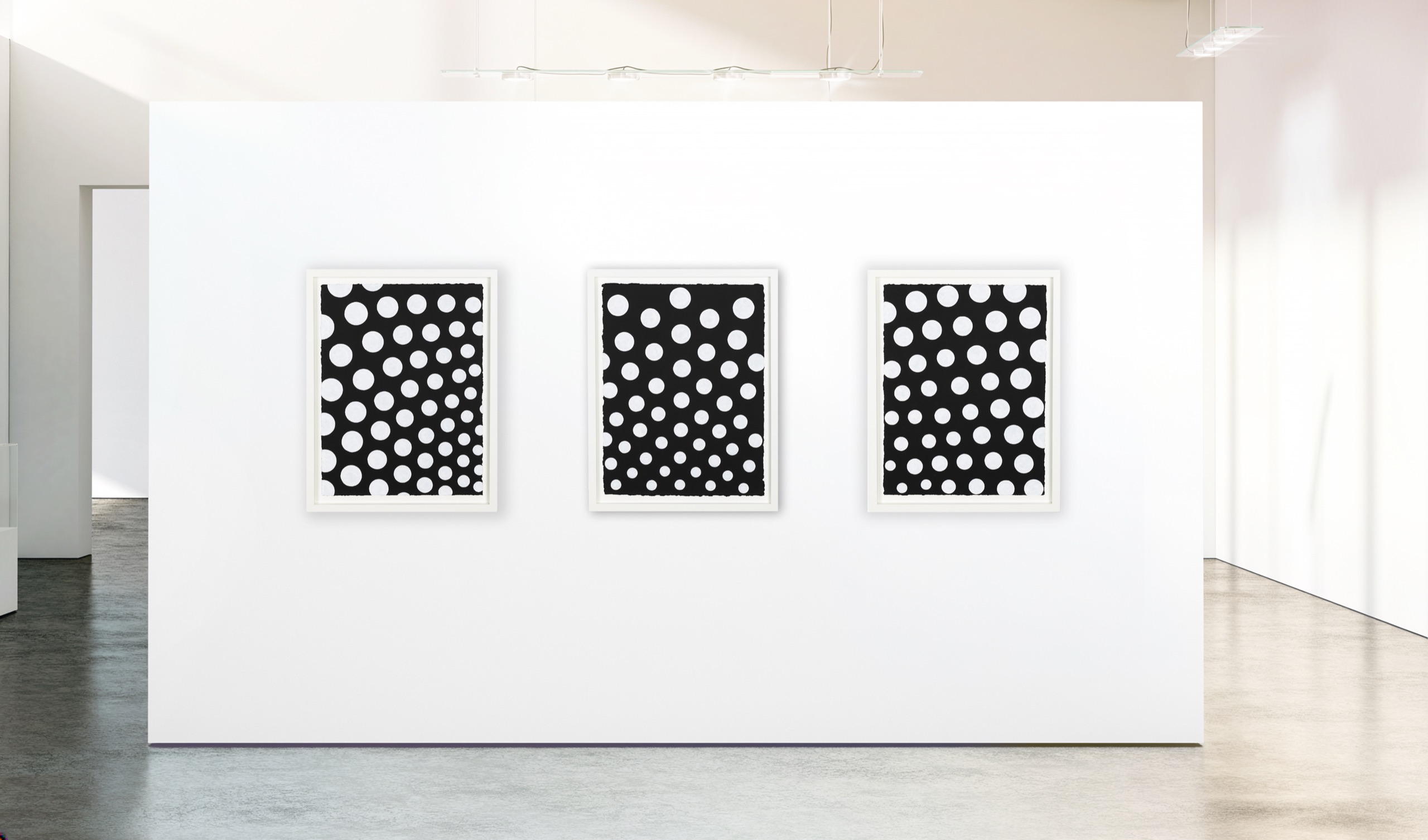 Three framed dot paintings on handmade paper hanging in a white gallery.